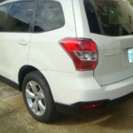 Before and after photographs of a damaged white Subaru that was repaired by Elite Paint & Body Shop in West Palm Beach, Florida